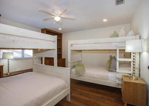 a bedroom with two bunk beds and a ceiling fan at Karens Cottage in Fairhope