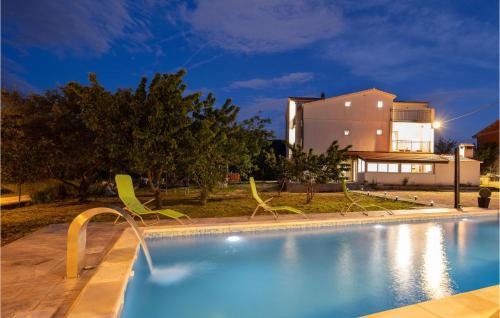 a swimming pool with chairs in front of a house at Cozy Home In Neoric With Wifi in Neorić