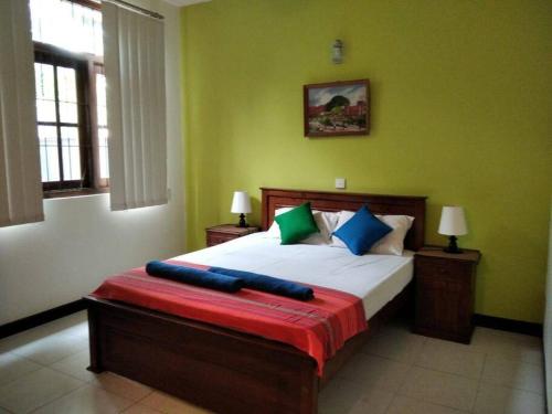ein Schlafzimmer mit einem großen Bett mit einer roten Decke darauf in der Unterkunft A tropical paradise; stunning house, pool, garden in Wattala
