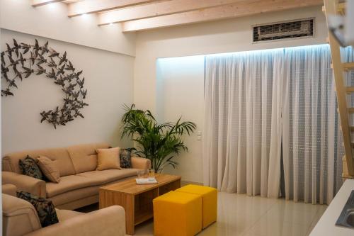 a living room with a couch and a table at Liberte Maisonettes in Parga