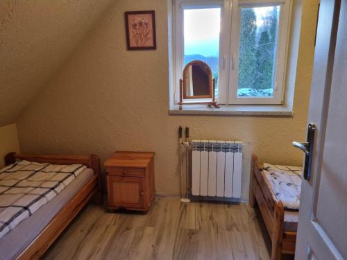 1 Schlafzimmer mit 2 Betten und einem Fenster in der Unterkunft DOMEK NA BASZCIE klimatyzowany in Lesko