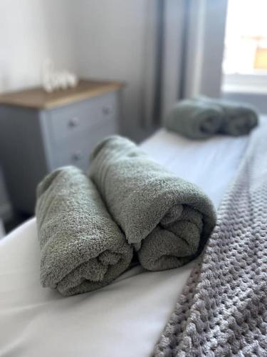 a pile of towels sitting on top of a bed at Cosy apartment in Eccleshall in Eccleshall