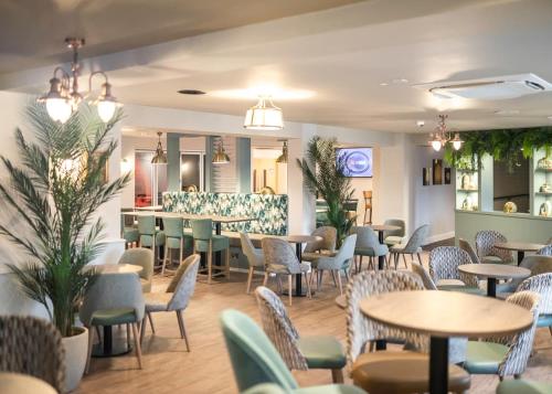 um restaurante com mesas e cadeiras e um bar em Shorefield Country Park em Milford on Sea