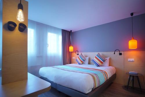 a bedroom with a large white bed with pillows at La Regence in Courbevoie