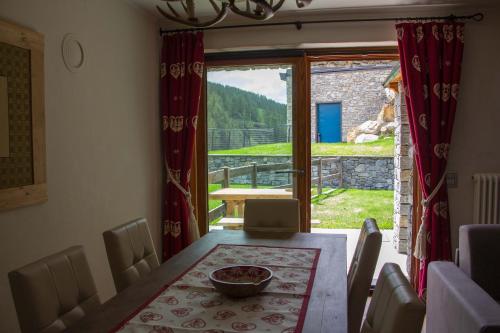 ein Esszimmer mit einem Tisch und einem großen Fenster in der Unterkunft Maison Carrel Elegant 1 in Breuil-Cervinia