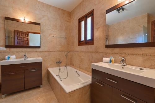 a bathroom with two sinks and a bath tub and a tubermott at Casa Renata in Jávea