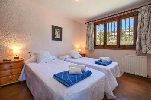 a bedroom with two beds with blue towels on them at Casa Renata in Jávea