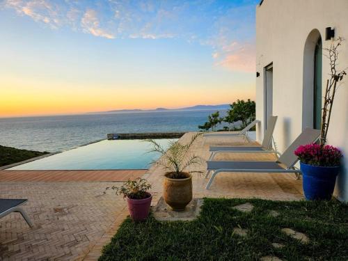 a group of benches sitting on the side of a house at Très belle villa avec piscine et vue incroyable sur mediterannée (DAR NAIM) in Tangier