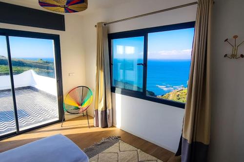 a bedroom with a large window with a view of the ocean at Très belle villa avec piscine et vue incroyable sur mediterannée (DAR NAIM) in Tangier
