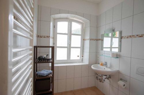 a white bathroom with a sink and a window at Nickis Gleis in Grafenau