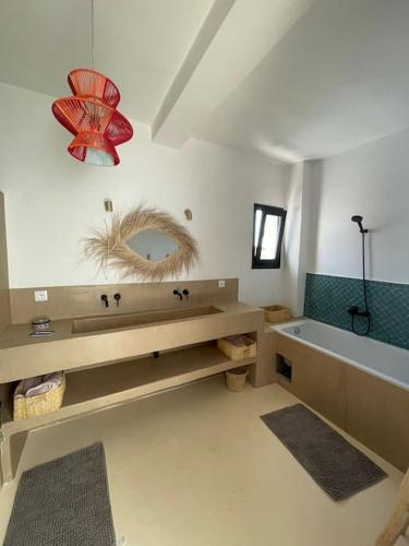 a bathroom with a sink and a tub and a mirror at Très belle villa avec piscine et vue incroyable sur mediterannée (DAR NAIM) in Tangier