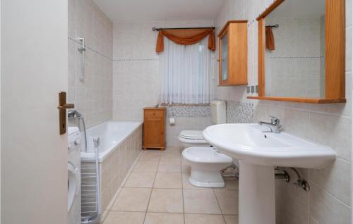 La salle de bains est pourvue d'un lavabo, de toilettes et d'une baignoire. dans l'établissement Beautiful Home In Labin With Wifi, à Labin