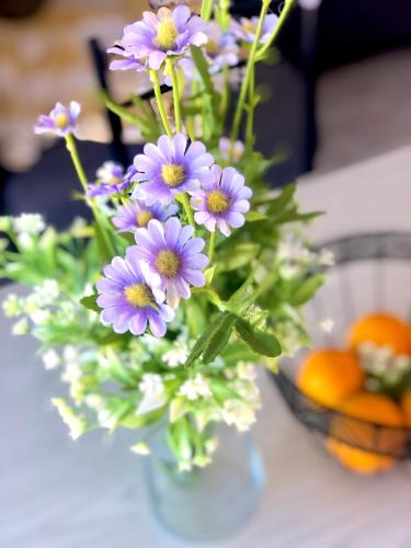 a vase filled with purple flowers on a table at Fuerteventura Beach Vacations and Blue Mango surf&fitness center at charco in Puerto del Rosario
