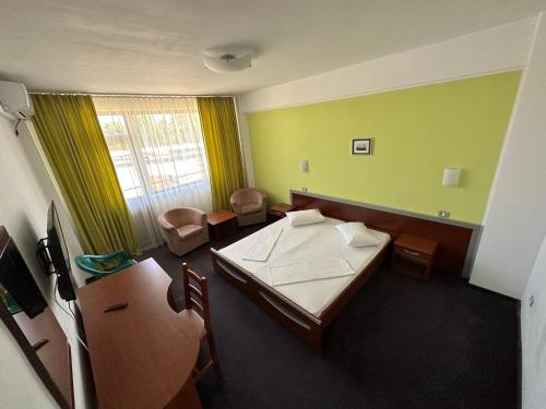 Hostel Stefania في كوستينيشت: غرفة بسرير وطاولة وكراسي