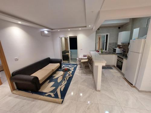 ein Wohnzimmer mit einem Sofa und einer Küche in der Unterkunft حي الواحات in Tunis