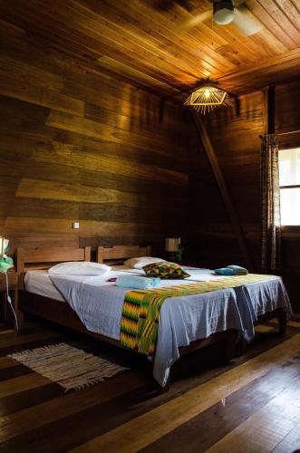 a bedroom with a bed in a wooden room at Hotel Praia Inhame Ecolodge in Porto Alegre