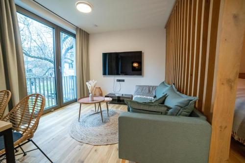 Una sala de estar con un sofá y un televisor. en Anders Apartments, en Jena
