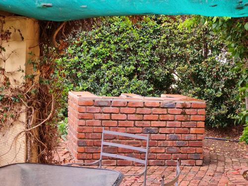 a chair sitting in front of a brick wall at Villa Tarentaal in Tulbagh
