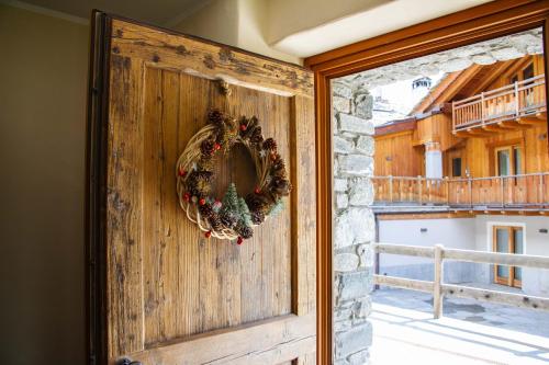 Una puerta con una corona de Navidad. en Maison Carrel Elegant 2, en Breuil-Cervinia