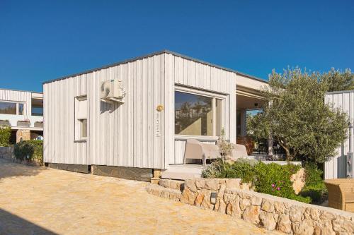 biały budynek z 2 krzesłami i kamienną ścianą w obiekcie BUQEZ VILLAS - Vanellus Villas w mieście Drage