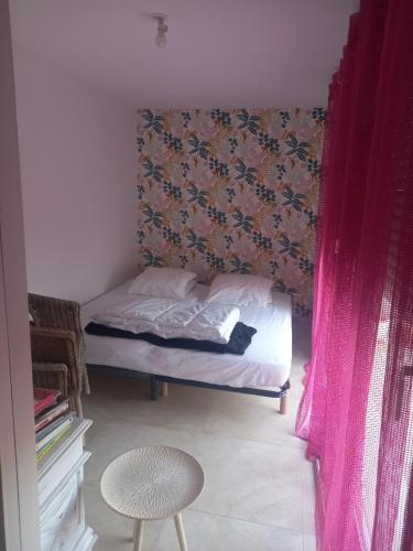 Un dormitorio con una cama con un gato negro. en Mérignac, en Mérignac