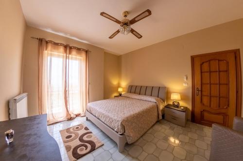una camera con letto e ventilatore a soffitto di Tenuta La Promessa - Irpinia a Torella deʼ Lombardi