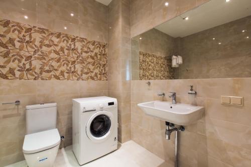 a bathroom with a washing machine and a sink at Katrin Apartments in Jūrmala