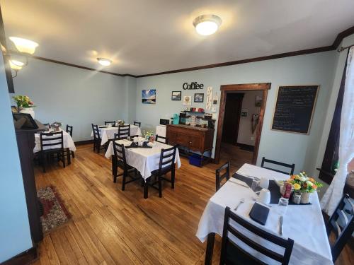 uma sala de jantar com mesas e cadeiras e um quadro-negro em The Harbourside Inn & Cafe em Port Union