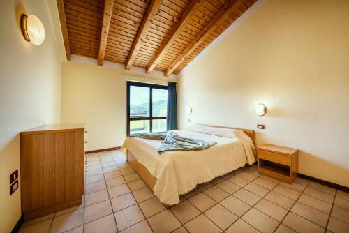 sypialnia z łóżkiem i oknem w obiekcie Hotel Residence Campi w Tremosine Sul Garda