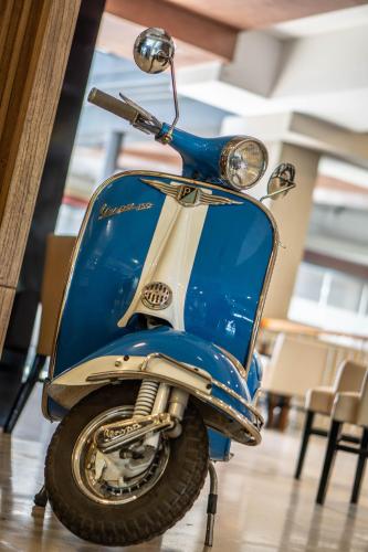 a blue scooter parked in a room with chairs at Mod Hotels Mendoza in Mendoza