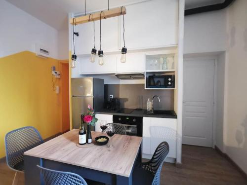 une cuisine avec une table et des chaises en bois dans l'établissement Le Favrel - Appartement avec mezzanine rénové - Gare de Vannes, à Vannes