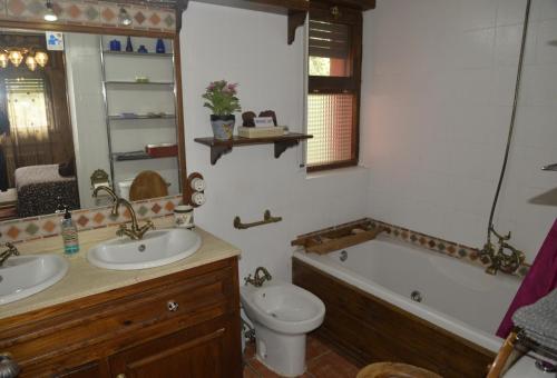 a bathroom with a sink and a toilet and a tub at LA CASA DE GALAPAGAR ALOJAMIENTO SIETE PICOS in Galapagar