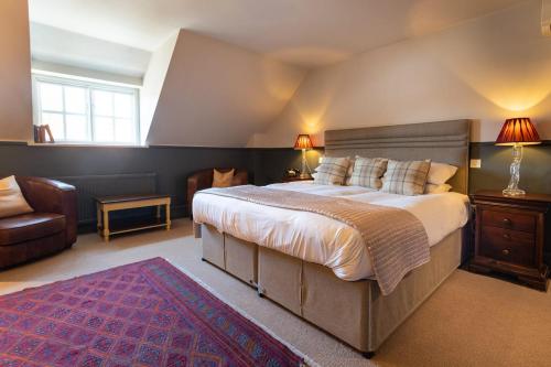 a large bedroom with a large bed and a couch at The Hoste and The Vine House Hotels in Burnham Market