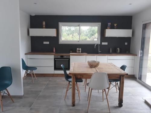 eine Küche mit einem Holztisch und Stühlen in der Unterkunft la brasserie in Migné-Auxances