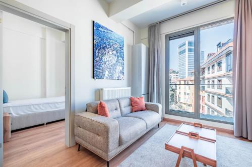 Homie Suites - Newly-constructed Apartment Complex in Beşiktaş في إسطنبول: غرفة معيشة مع أريكة ونافذة كبيرة