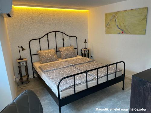 um quarto com uma cama com uma moldura de metal preto em Murter-Sun Stone House em Murter