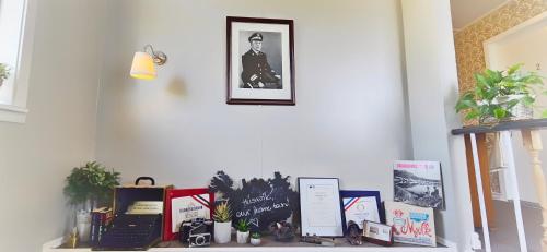 a shelf with books and a picture on a wall at Árból Guesthouse in Húsavík
