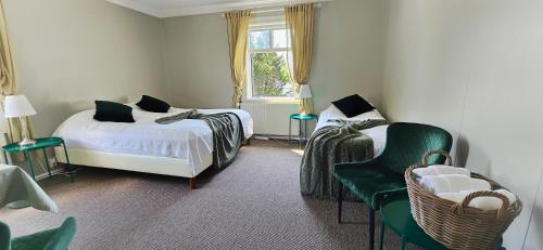 胡薩維克的住宿－阿波爾旅館，一间卧室设有两张床、一把椅子和一个窗户。