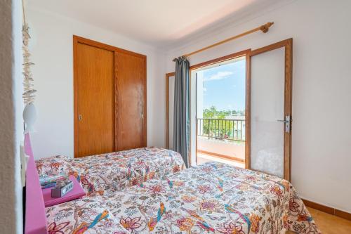 een slaapkamer met een bed en een groot raam bij Gran Sol Family 5 in Felanitx