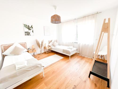 a white room with a bed and a ladder at theSunset Club - SUITE L Balkon - Küche - Parkplatz in Memmingen