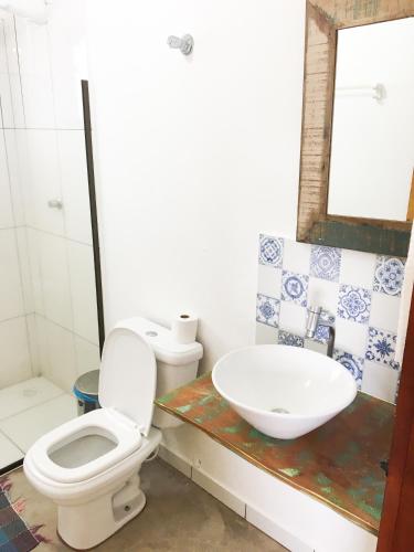 a bathroom with a toilet and a sink at Pousada das Estrelas in Itaúnas