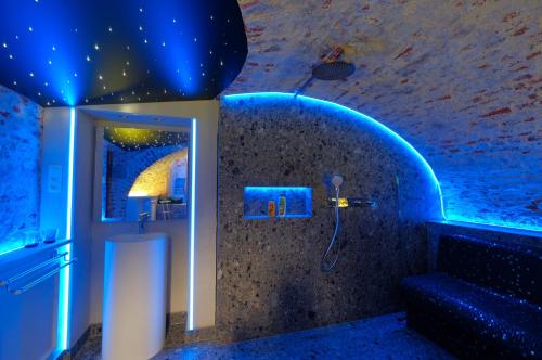 a bathroom with a shower with a blue lighting at Secret Jacuzzi Mons - Parking privé gratuit in Mons