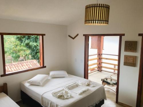 a bedroom with a bed and a large window at Pousada das Estrelas in Itaúnas