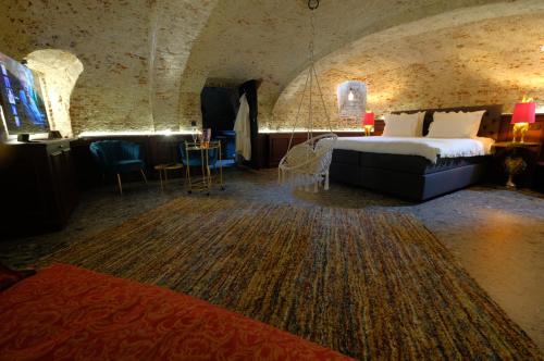 um quarto de hotel com uma cama, uma mesa e cadeiras em Secret Jacuzzi Mons - Parking privé gratuit em Mons