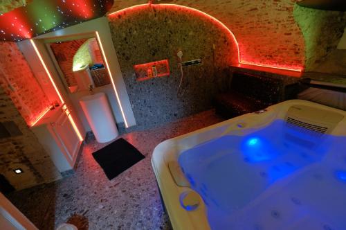 a bathroom with a bath tub in a room at Secret Jacuzzi Mons - Parking privé gratuit in Mons
