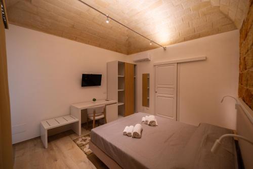 a bedroom with two towels on a bed with a desk at Butiko in Castelluzzo