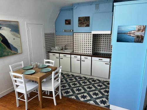- une cuisine avec une table en bois et des chaises blanches dans l'établissement Rêve d'horizon, appartement avec vue mer. (4 pers), à Saint-Valery-en-Caux