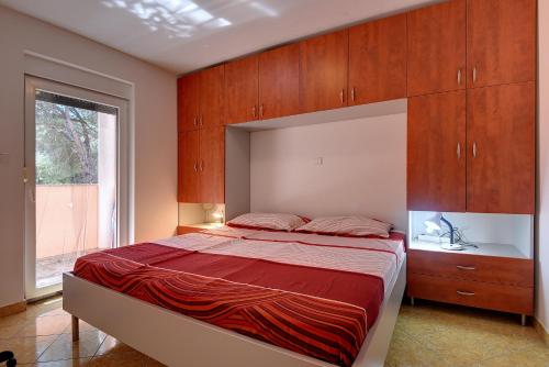 ein Schlafzimmer mit einem großen Bett mit Holzschränken in der Unterkunft Apartment Sana in Medulin