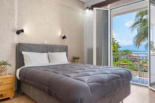a bedroom with a large bed and a balcony at ALEXANDROS B in Nikiana