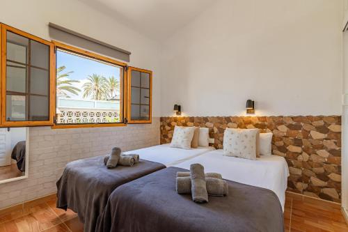 twee bedden in een kamer met een raam bij CANARIAN HOLIDAY HOME - Private Bungalow in Playa del Inglés in Maspalomas